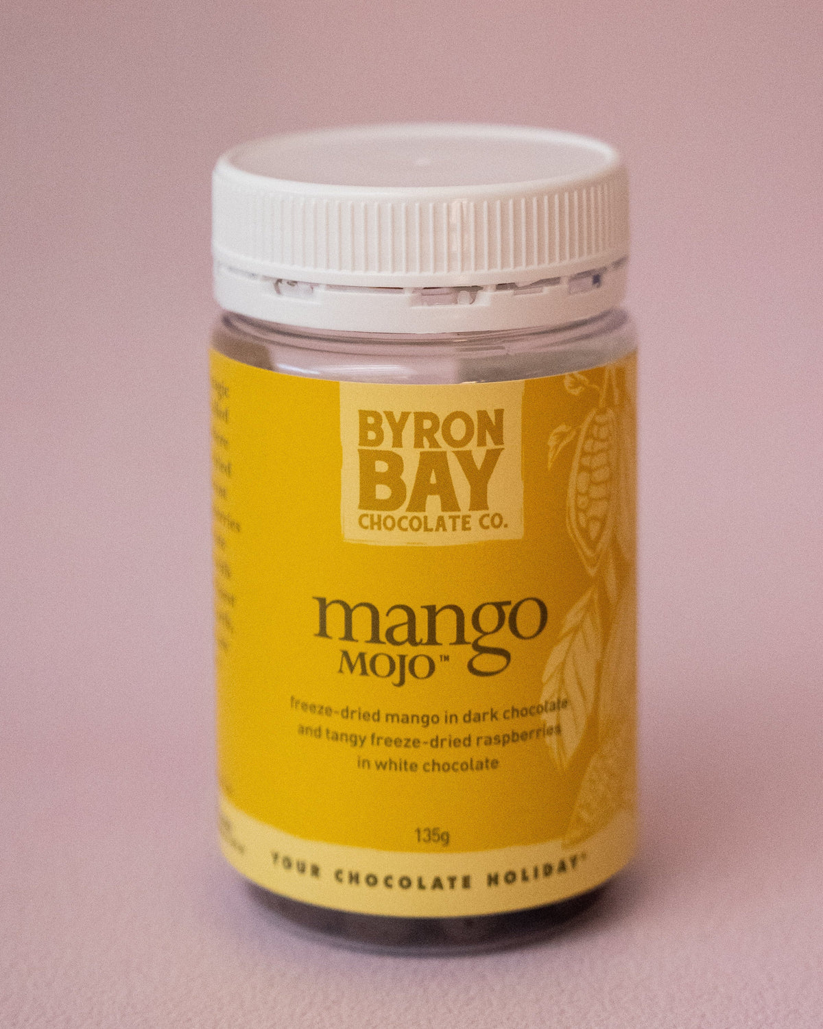 Jar of Byron Bay Chocolate Mango Mojo on a pink background