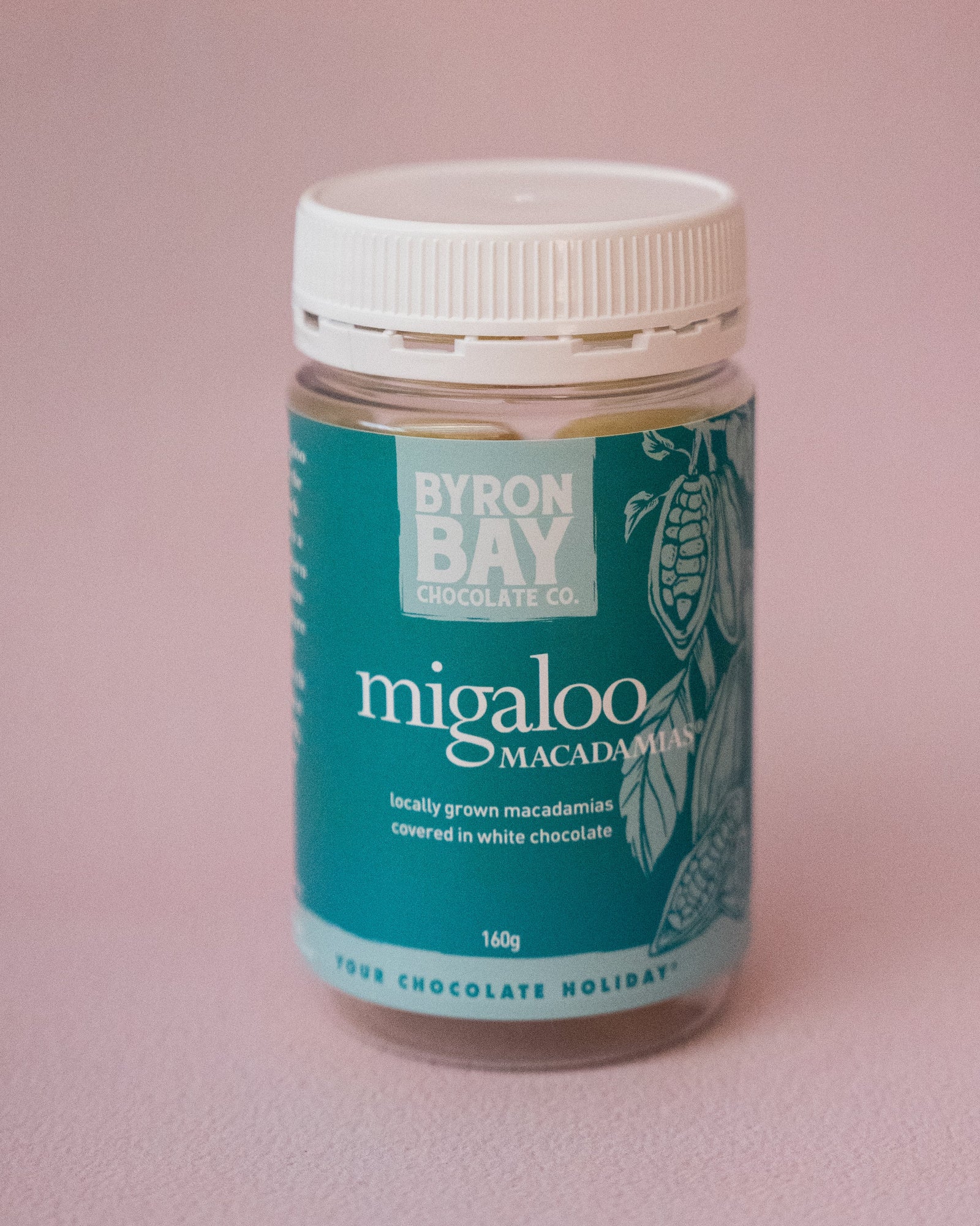 Jar of Byrch Bay Migaloo macadamia nuts on a pink background